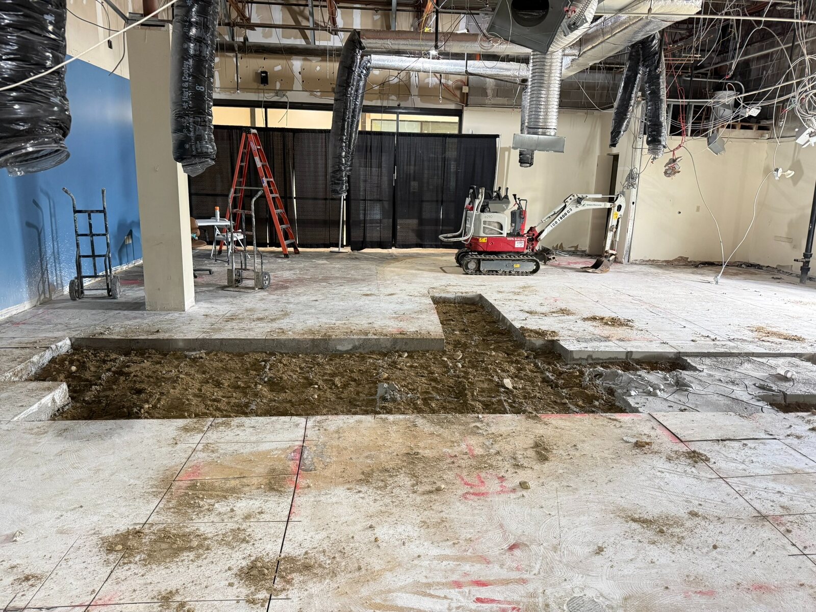 Floor trenching and construction equipment inside the restaurant space